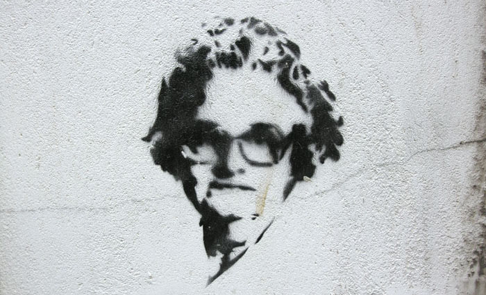A black stenciled image of an older woman applied to a white wall | All rights reserved by the image creator: Maarten Idema. Copyright 2006.